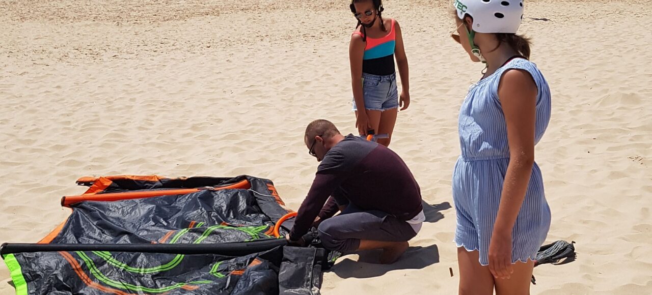 kitesurf group on the beach setting up kite